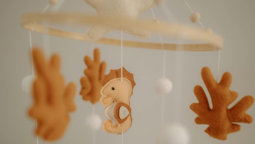 Felt sea creatures hanging from a crib mobile.