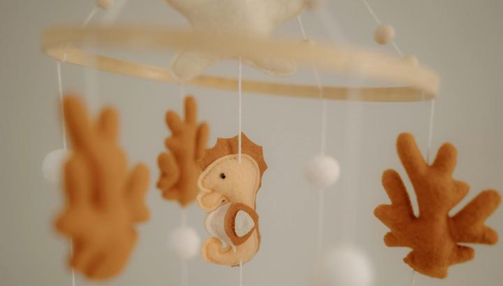 Felt sea creatures hanging from a crib mobile.
