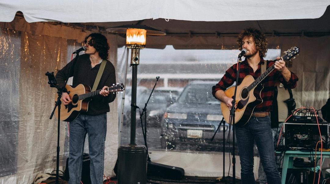 A small band performing outside during daytime.