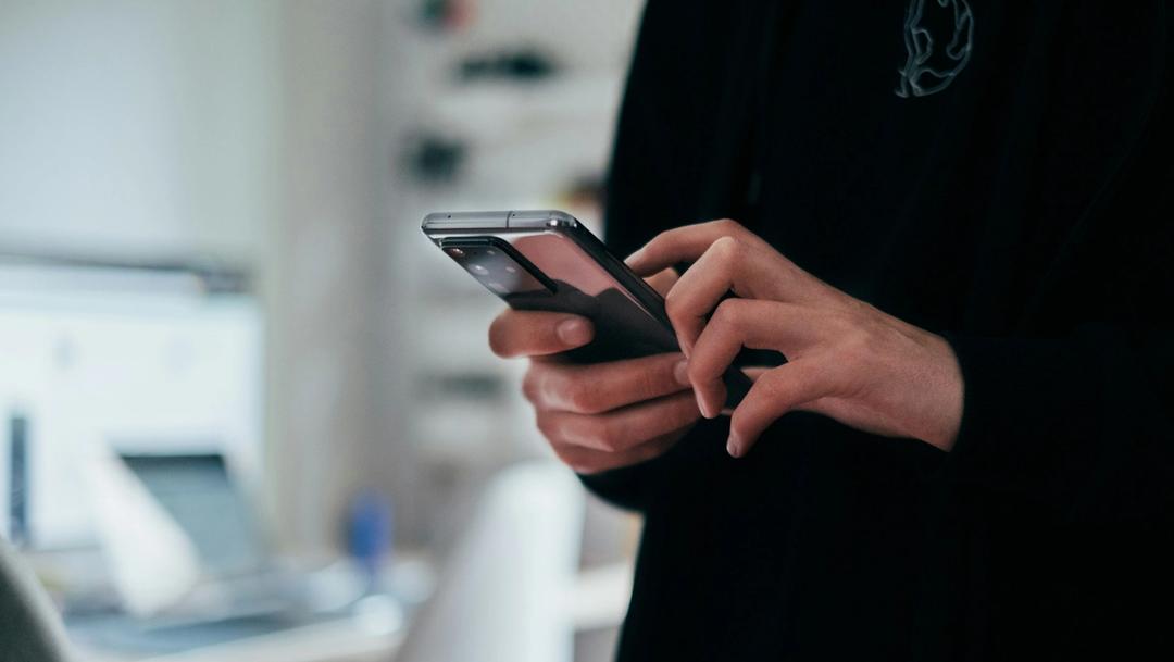 Person holding a black smartphone.