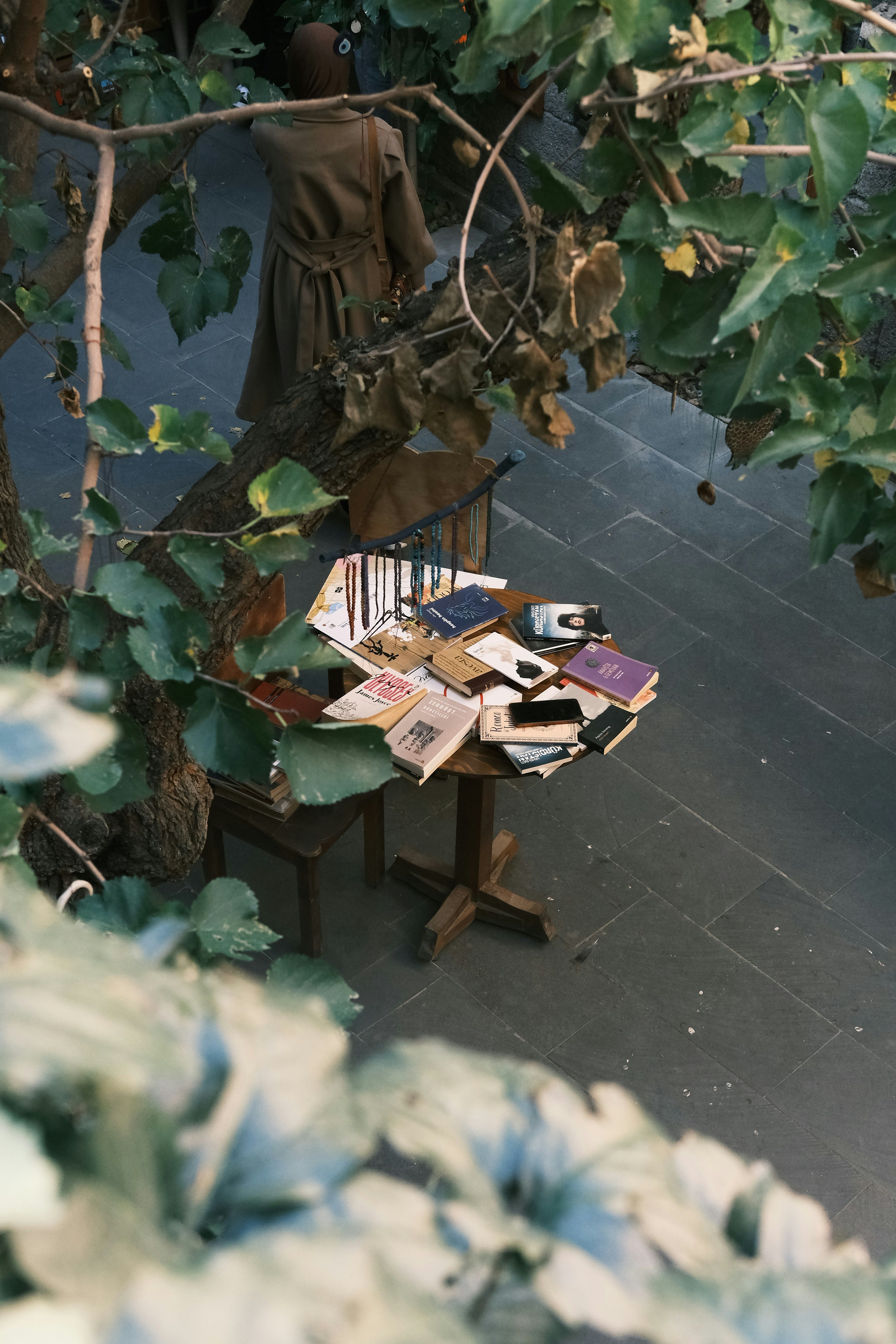 Books lying on a wooden table outside.