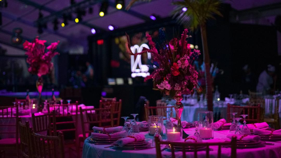 A table set up for a party with candles, flowers, and plates.