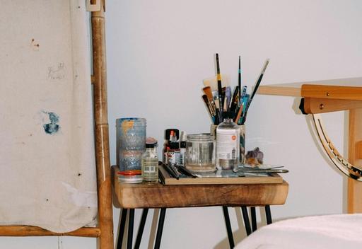 A room with an easel and paintbrushes.