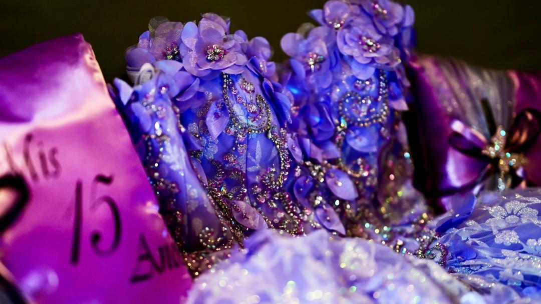 A close up of a purple quinceañera dress.