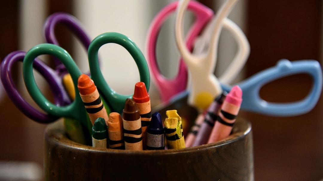 Scissors and crayons in a cup.
