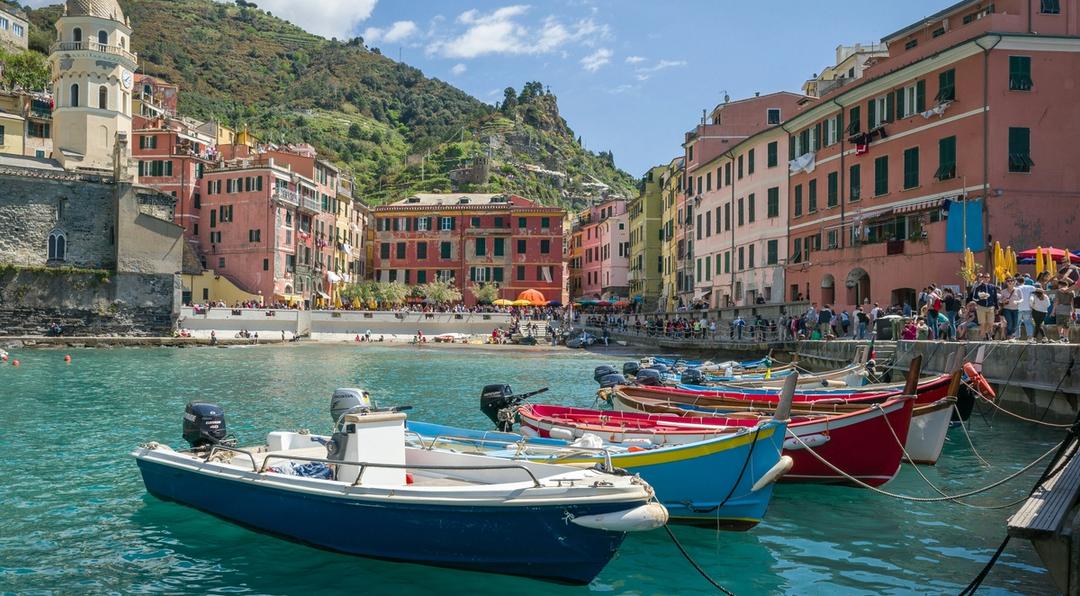 Boats floating in the water on a beach in Italy.