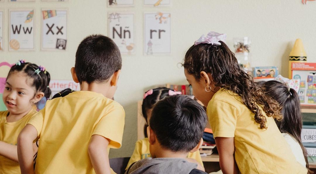 A group of children sitting at desks in a classroom.