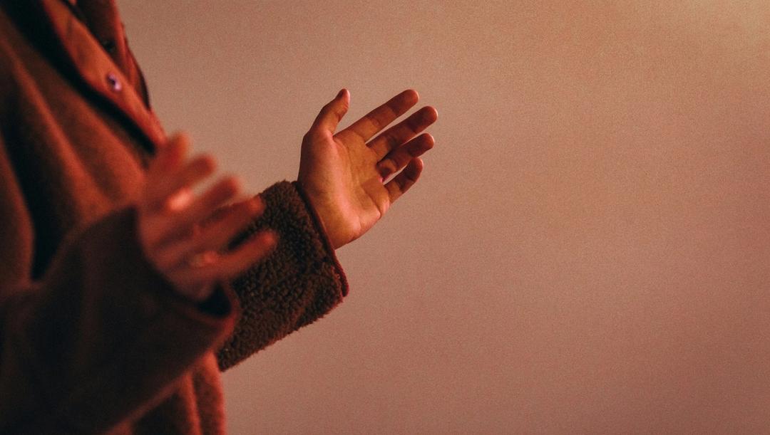 Person praising, preaching, or praying by using their hands.