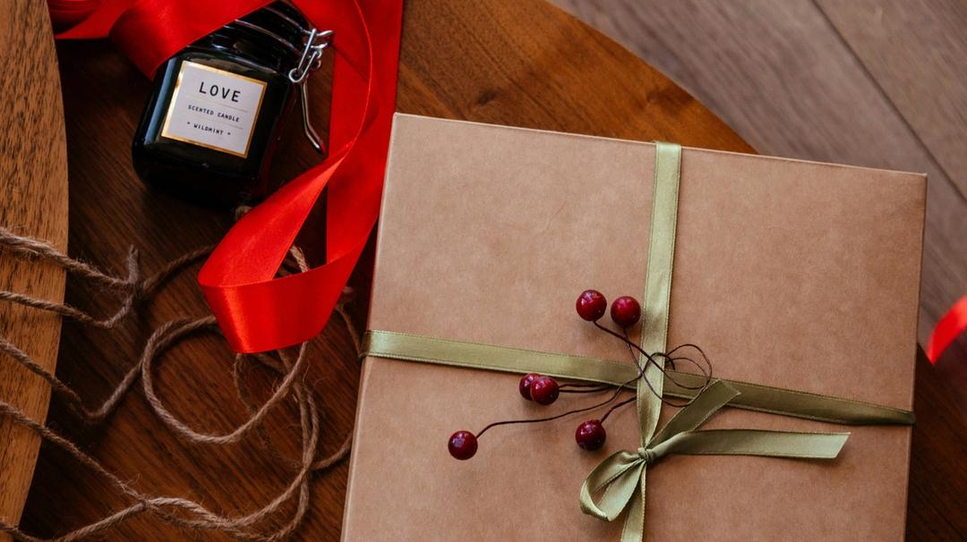 A wrapped present sitting on a wooden table.