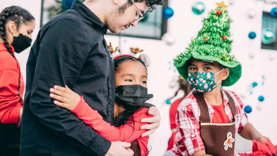 Young girl embracing a man at a holiday event.
