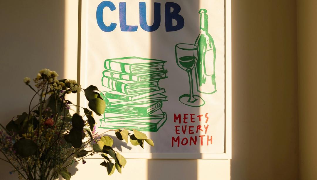 Painting hung up on a wall that says "club meets every month"