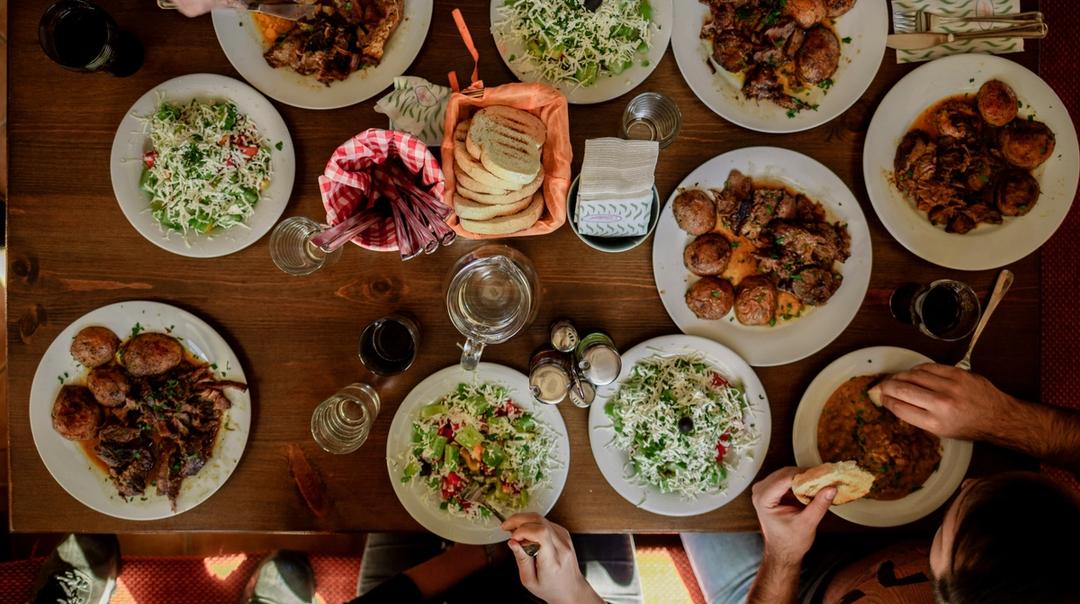 A dinner table with plates filled with assorted meals.