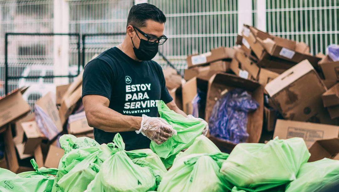 A man organizing bags full of donations.