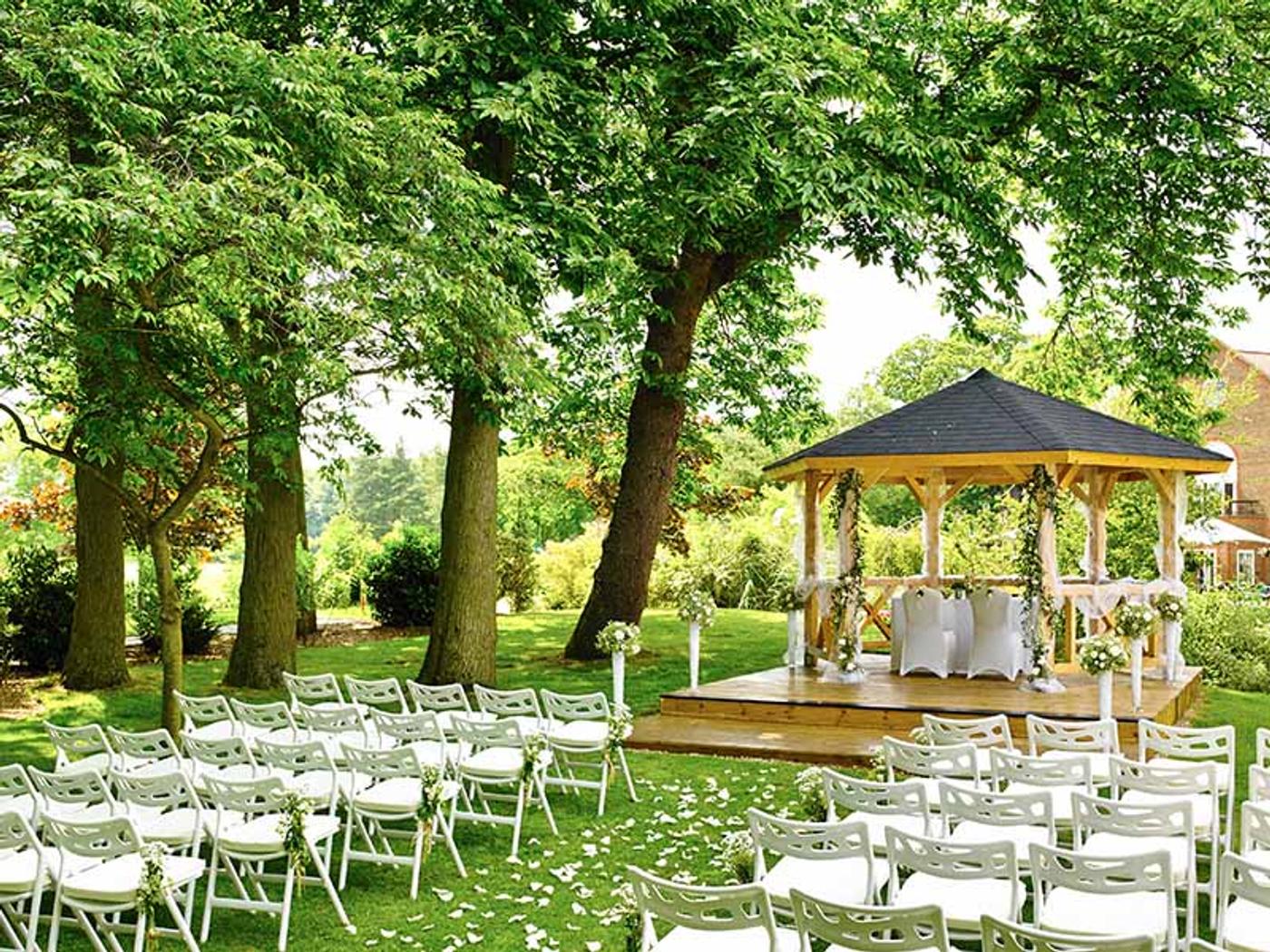 Delta Hotels by Marriott Tudor Park Country Club's gazebo dressed with white drapes and pink and white floral arrangements