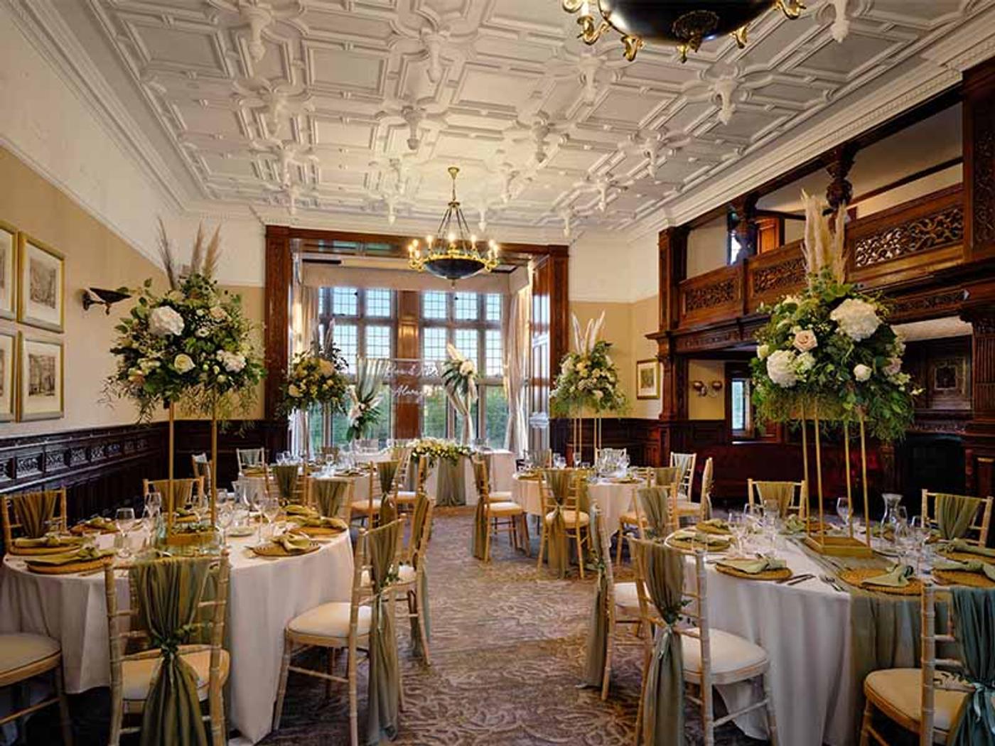 Haslam Room set for a wedding breakfast with tall floral centrepieces