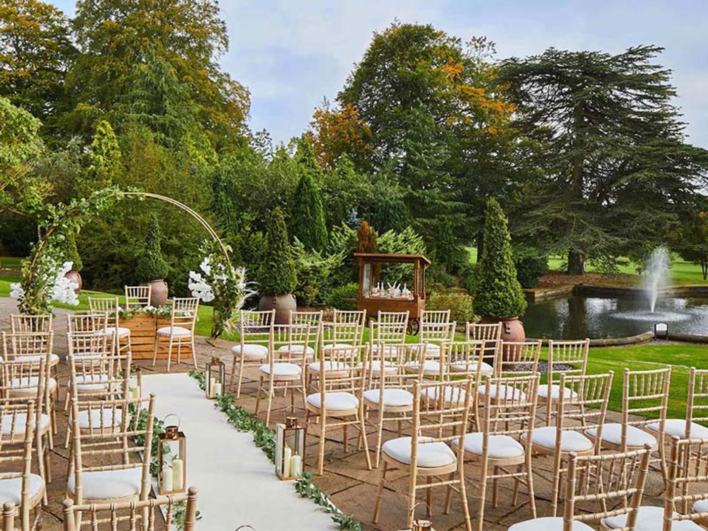 Outdoor ceremony setup beside the lake at Delta Hotels Breadsall Priory Country Club