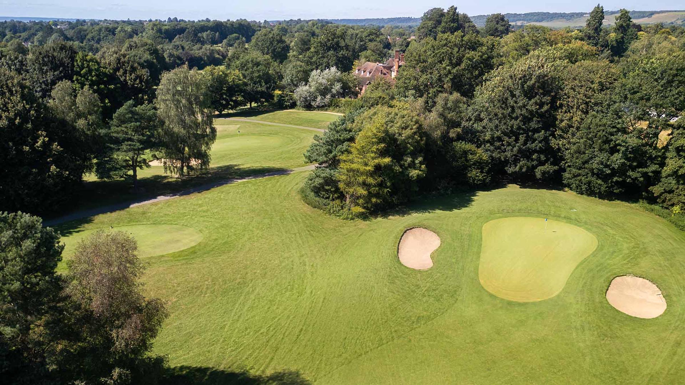 Aerial view of a green with bunkers surrounded by mature trees at Delta Hotels by Marriott Tudor Park Country Club
