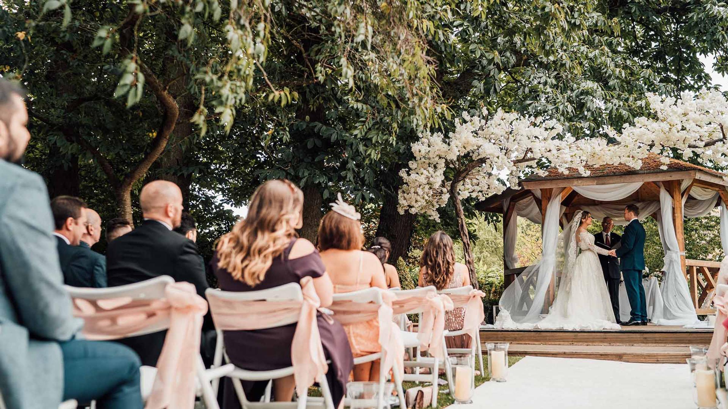 Bride and groom kissing beneath a flowering gazebo at Delta Hotels by Marriott Tudor Park Country Club