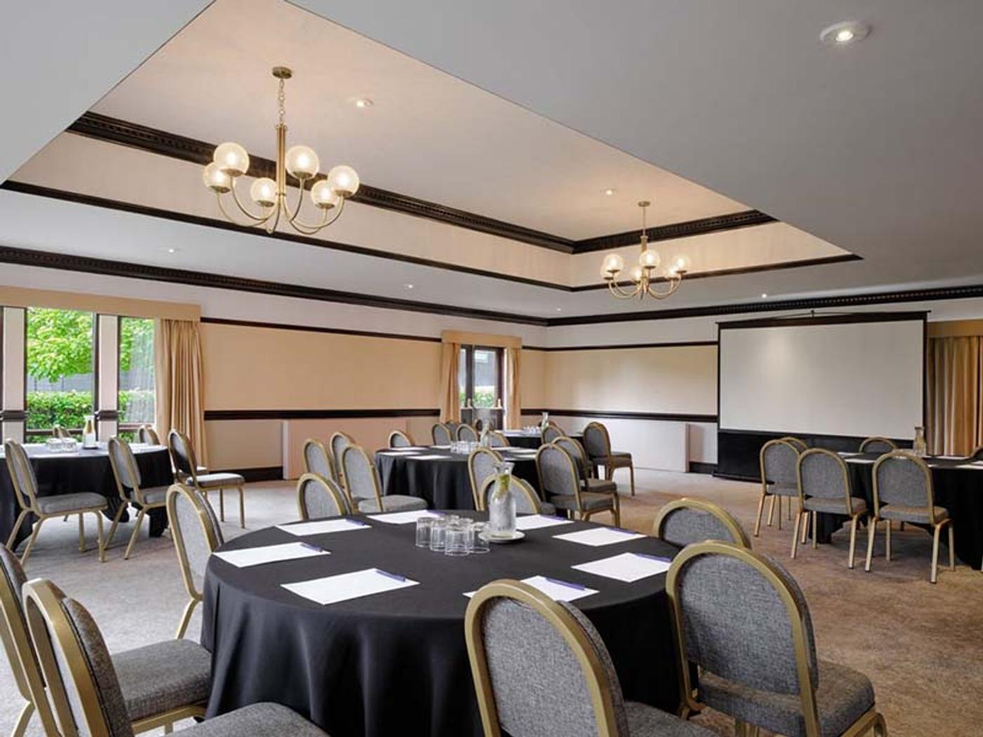 The Pavilion set up for an event with round tables and white chair covers