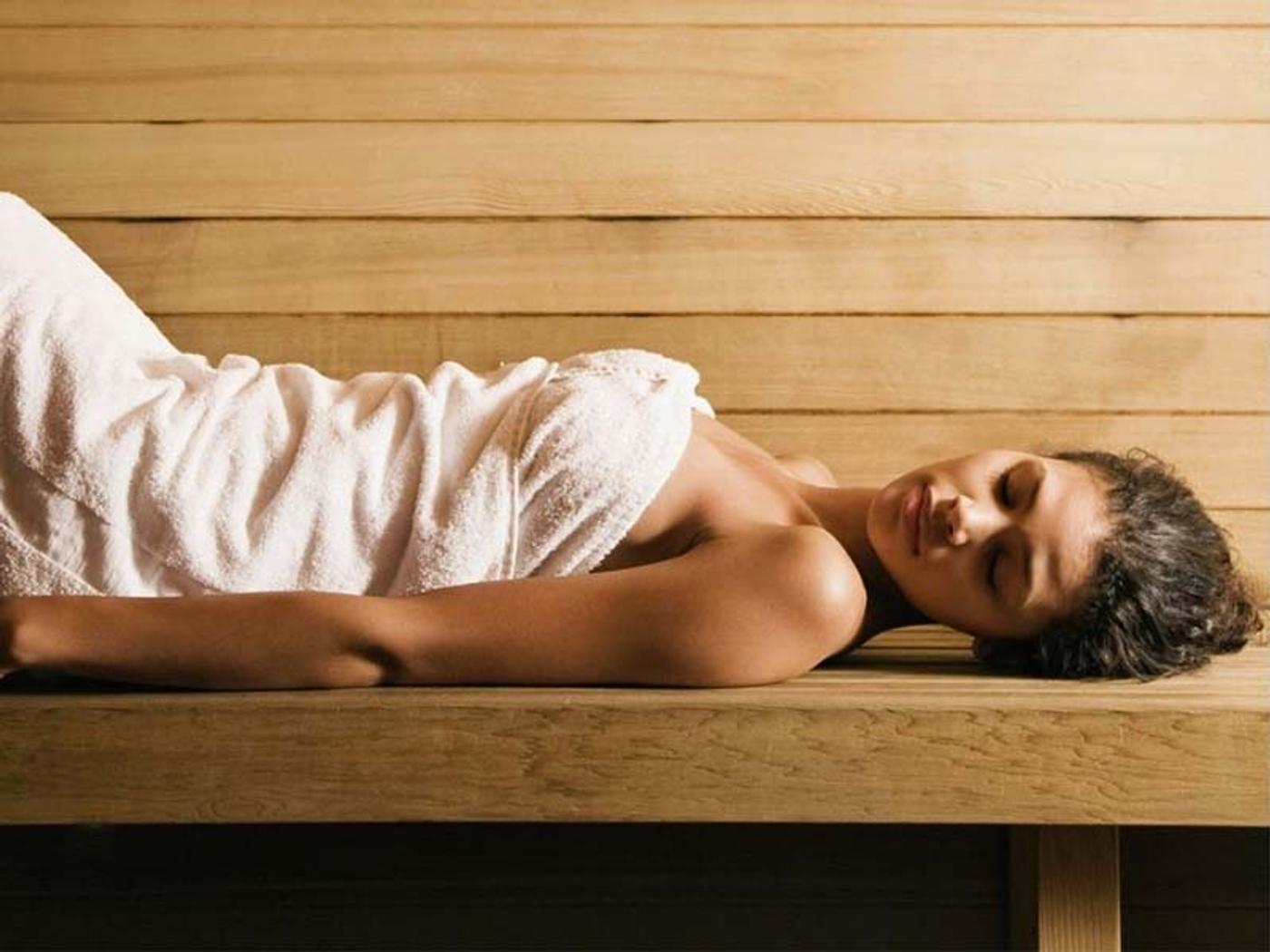 Guest relaxing wrapped in a towel in the sauna at The Beauty Rooms, Delta Hotels St. Pierre Country Club