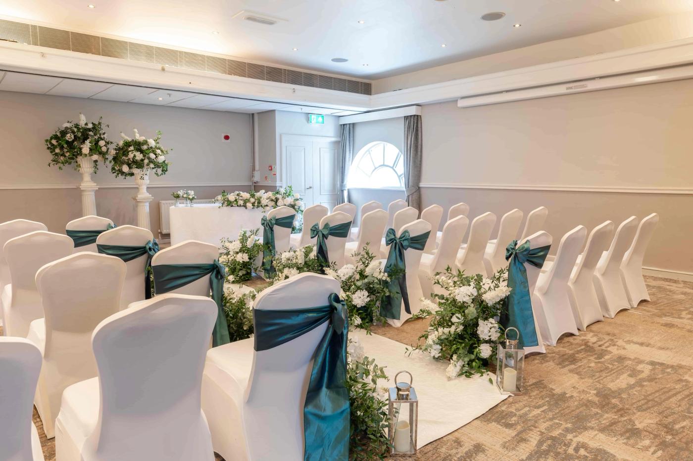 Thurnham Suite set up for a ceremony with teal chair sashes