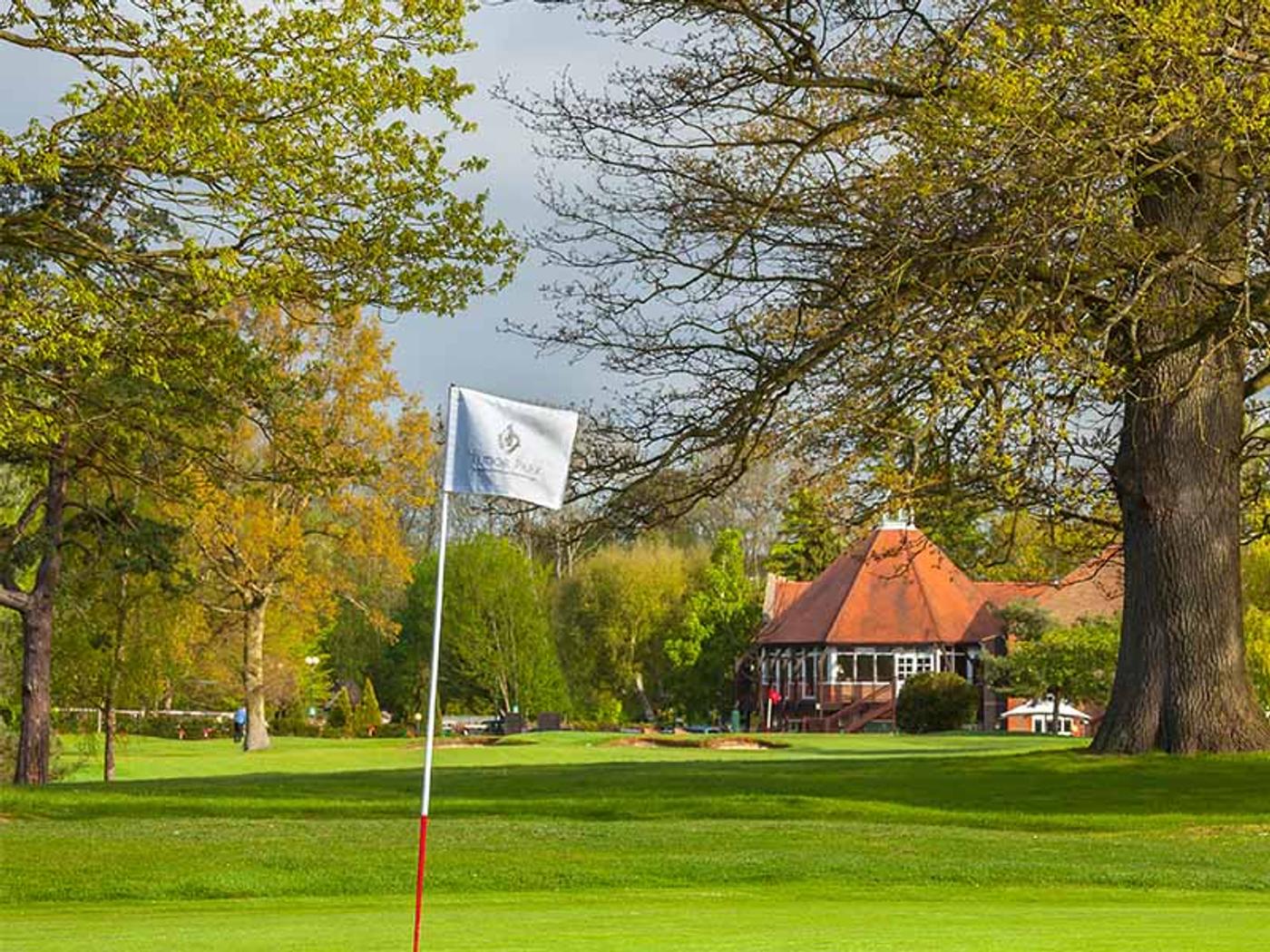 Green with flag and the clubhouse pavilion in the background at Delta Hotels by Marriott Tudor Park Country Club