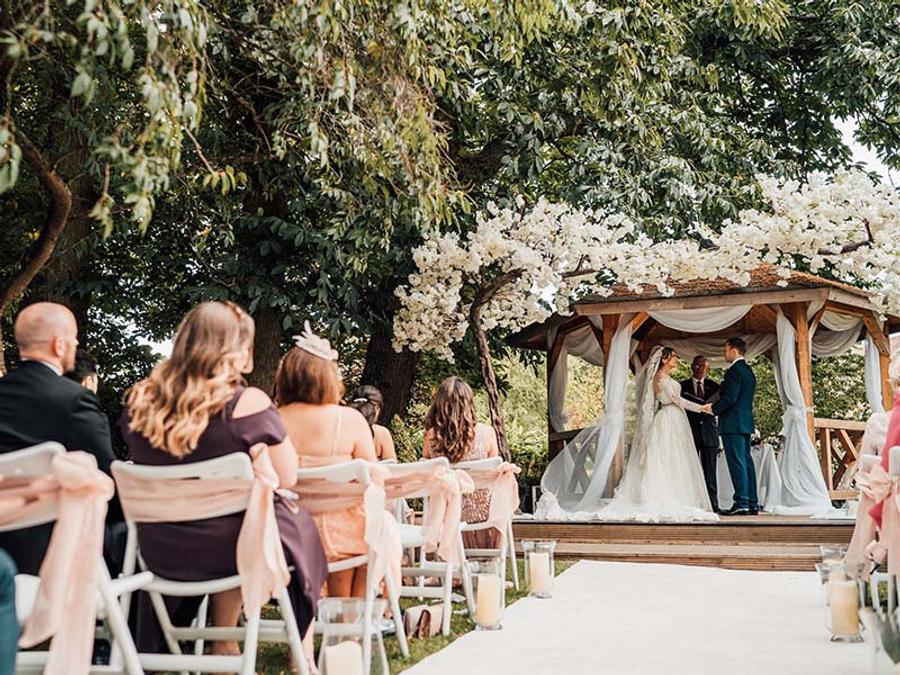 Outdoor wedding ceremony under a flowering gazebo at Delta Hotels by Marriott Tudor Park Country Club