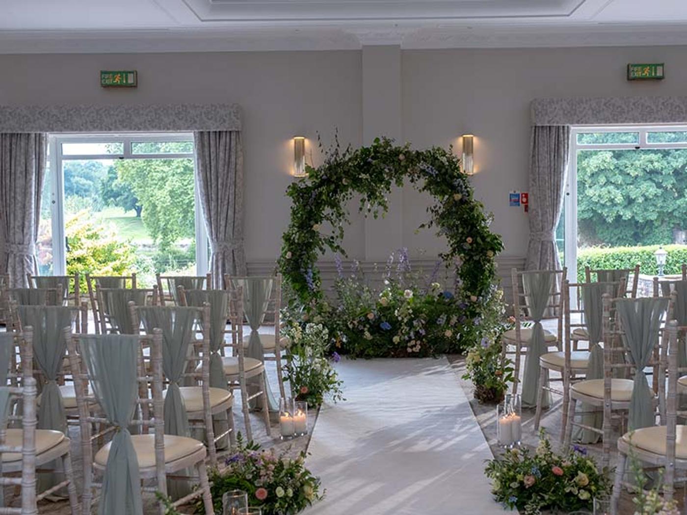 St. Pierre Suite set up for an indoor ceremony with a circular floral arch