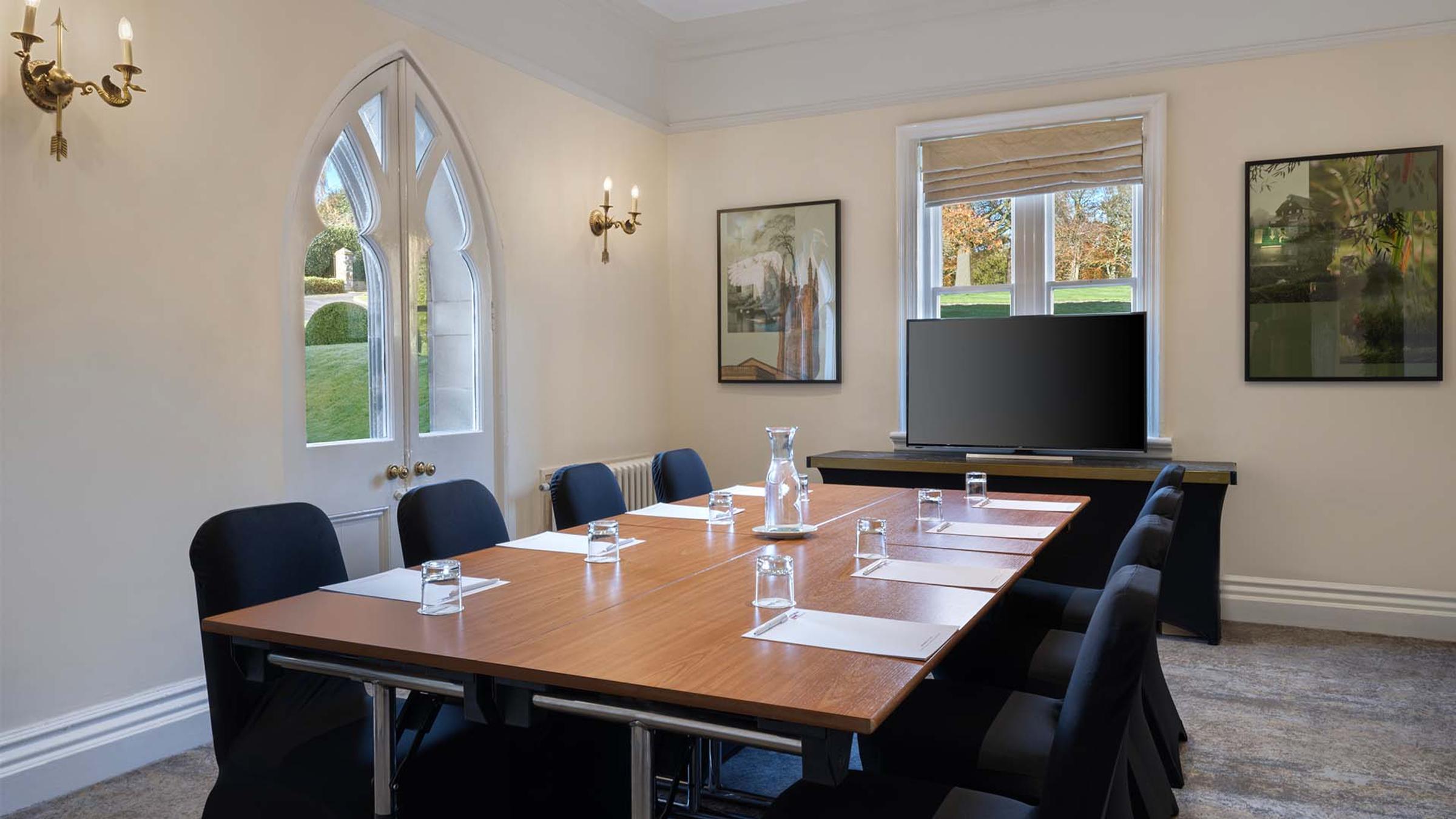 Meeting room set boardroom-style with a Gothic arched doorway at Delta Hotels Breadsall Priory Country Club