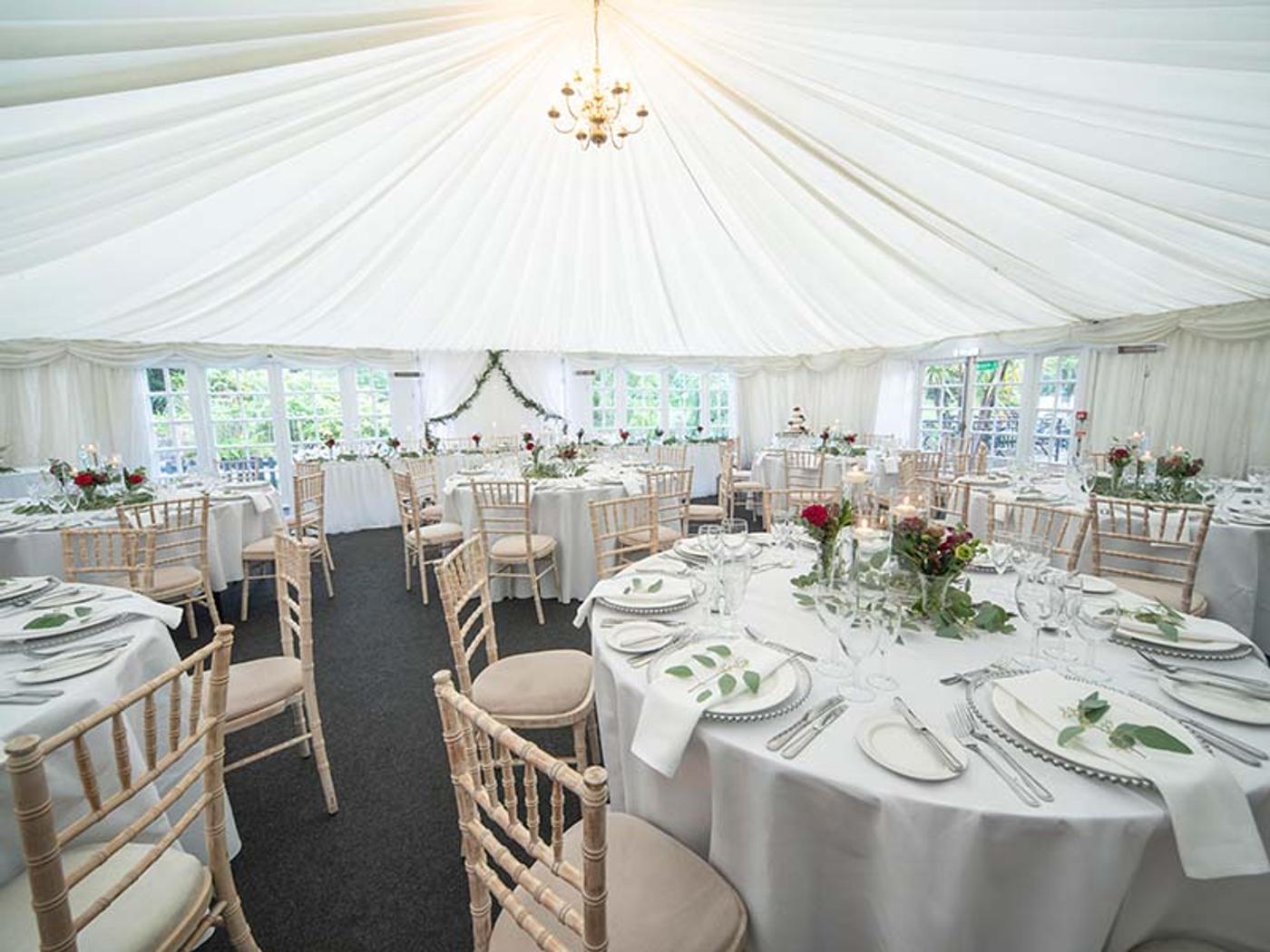 Marquee dining room set with chiavari chairs and floral centrepieces