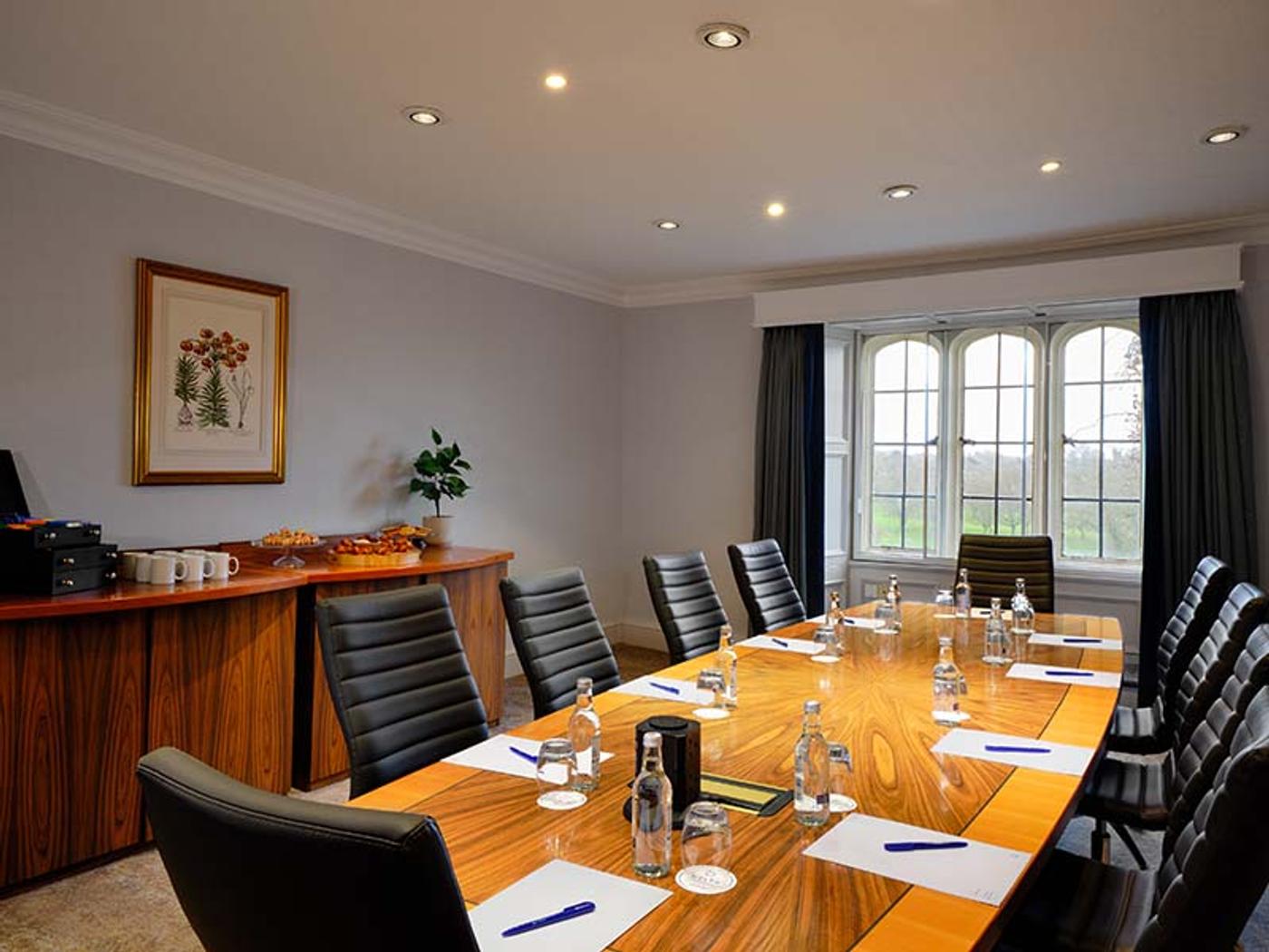 Meeting room with a boardroom table and sideboard overlooking the grounds
