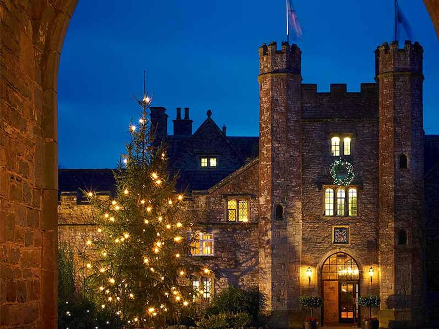 Delta Hotels St. Pierre Country Club's gatehouse lit up at night beside a Christmas tree