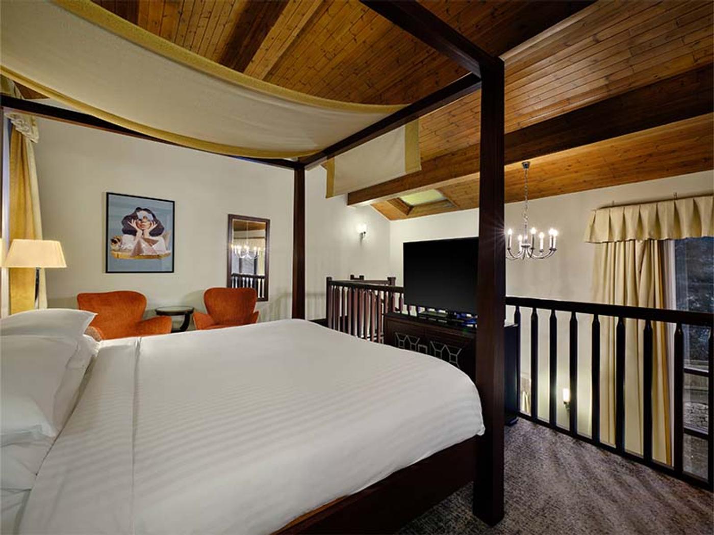 Loft bedroom suite with seating area and artwork