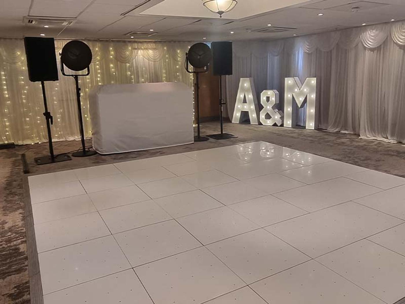 Bearsted Room set up for an evening reception with light-up A&M letters and a DJ booth