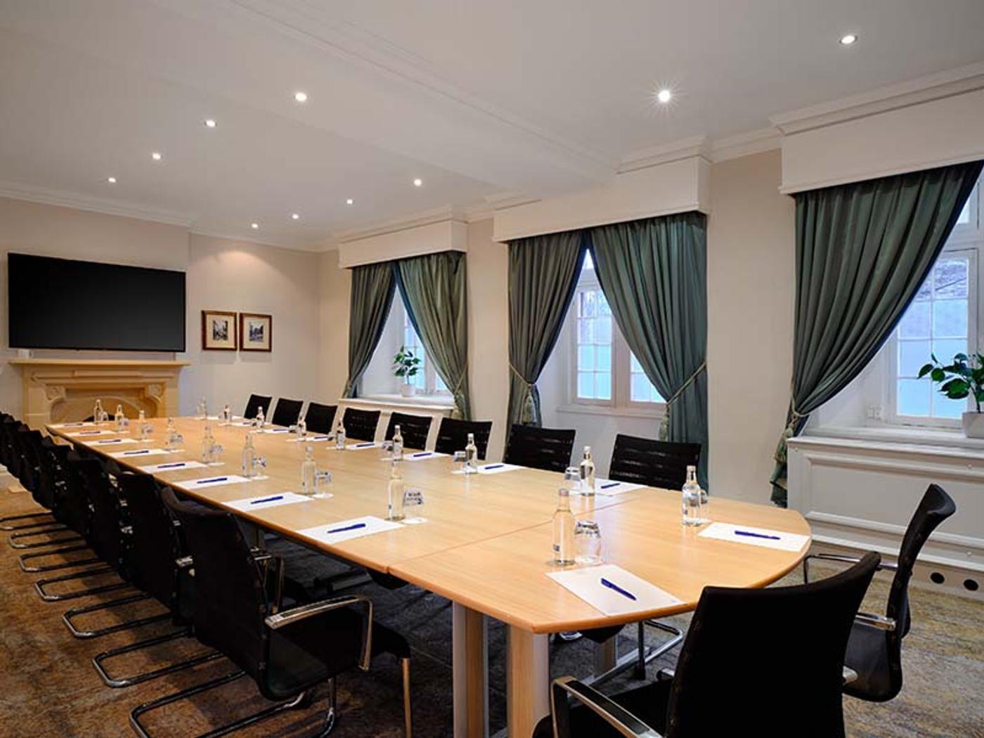 Boardroom-style meeting room with a fireplace and long oak table
