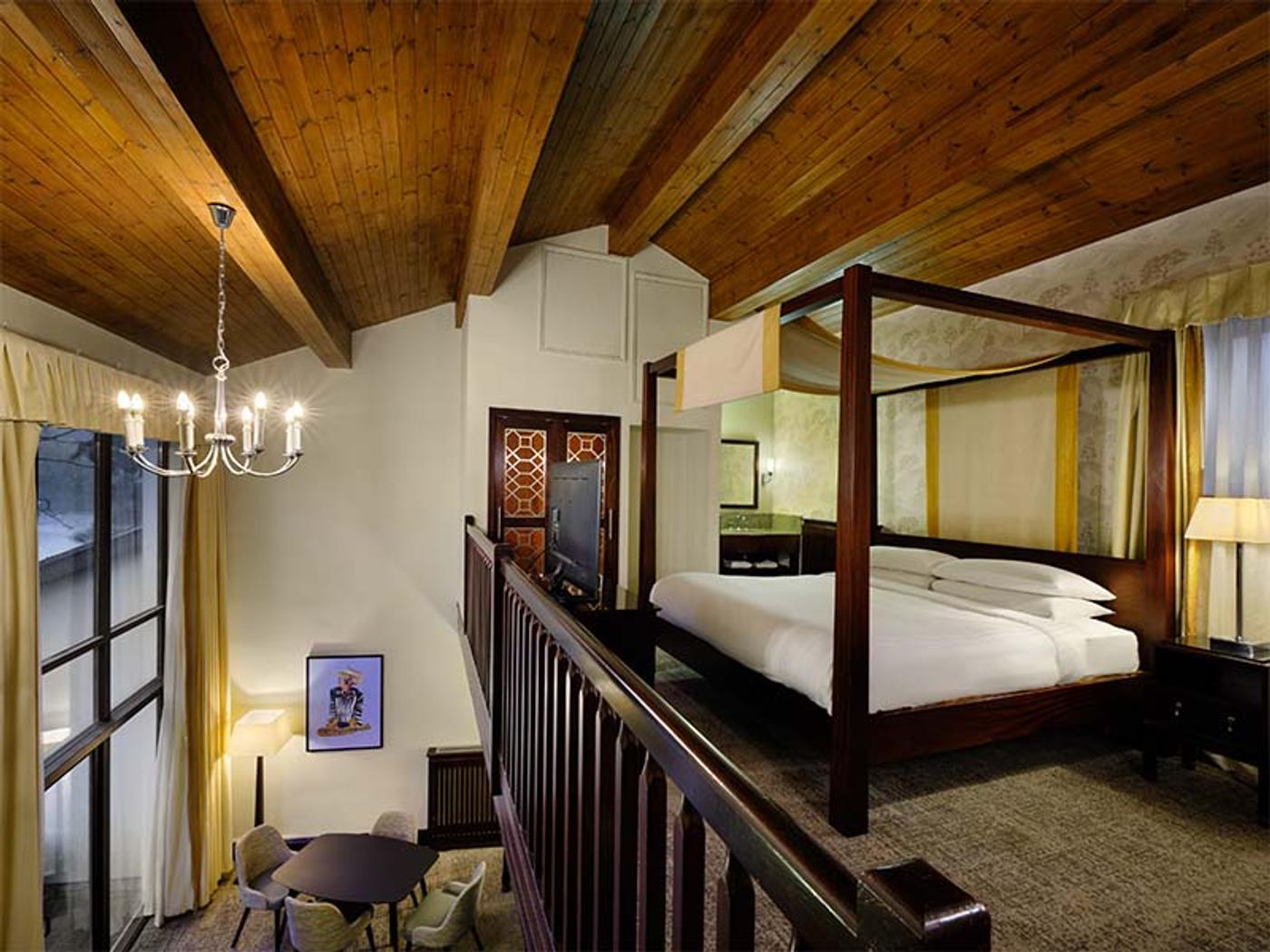 Lakeview Honeymoon Suite lounge with spiral staircase leading to the four-poster bed at Delta Hotels St. Pierre Country Club