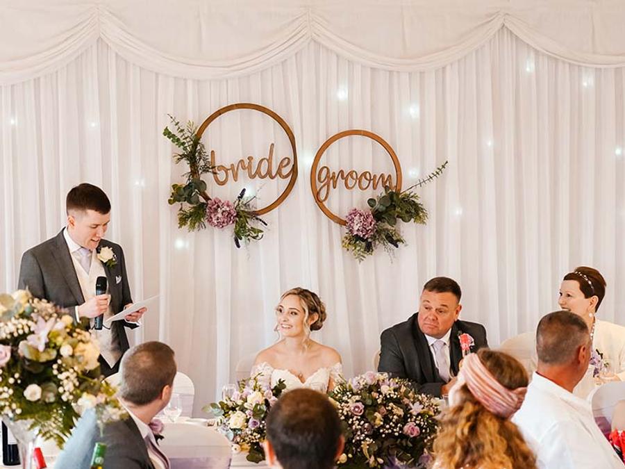 Wedding speech beneath bride and groom hoop decorations at Delta Hotels Breadsall Priory Country Club