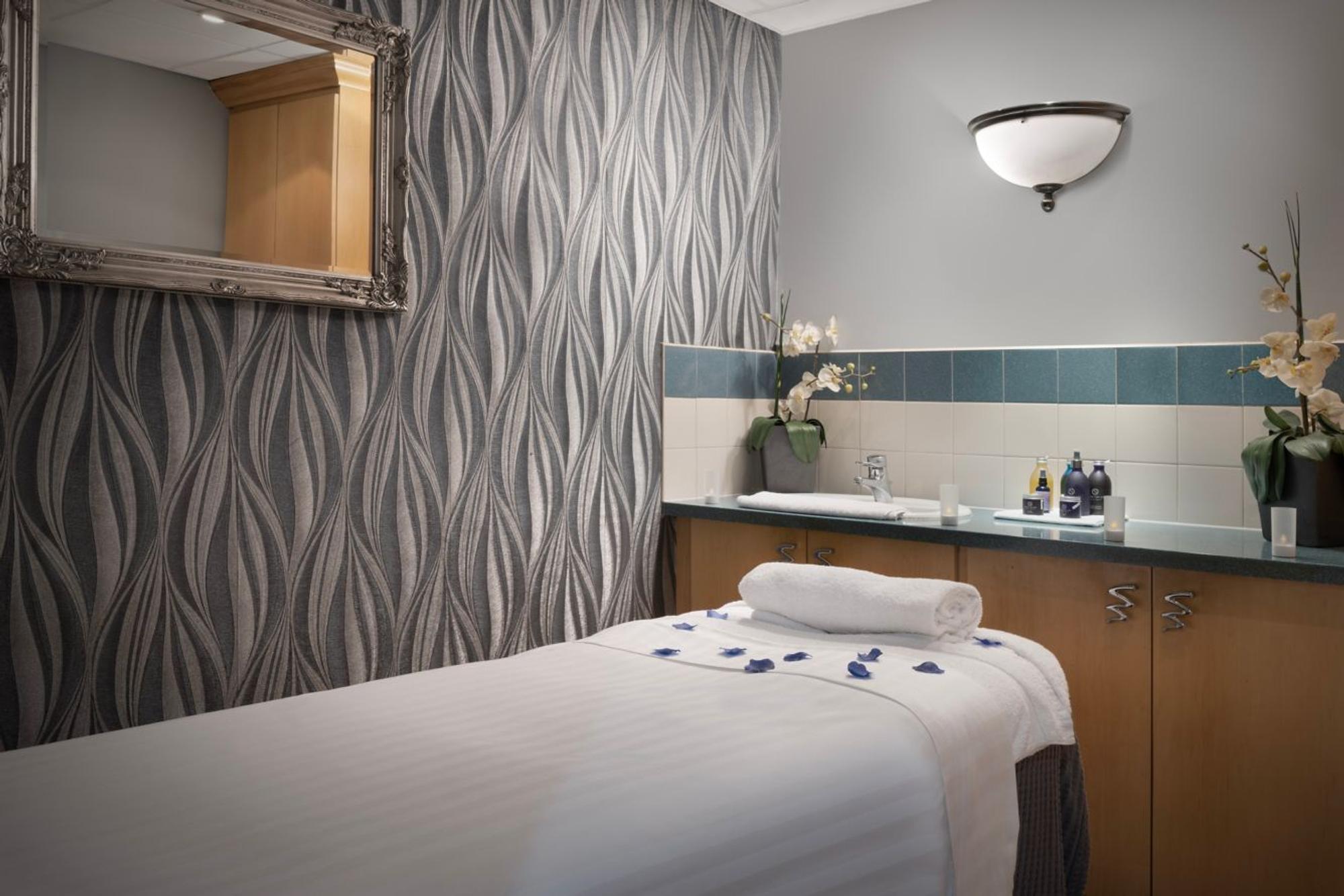 Delta Hotels by Marriott Tudor Park Country Club spa treatment room with towels and flowers