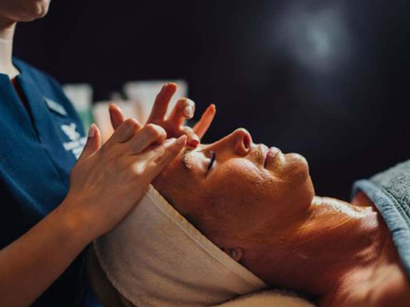 Therapist giving a relaxing facial treatment at Delta Hotels Breadsall Priory Country Club's spa