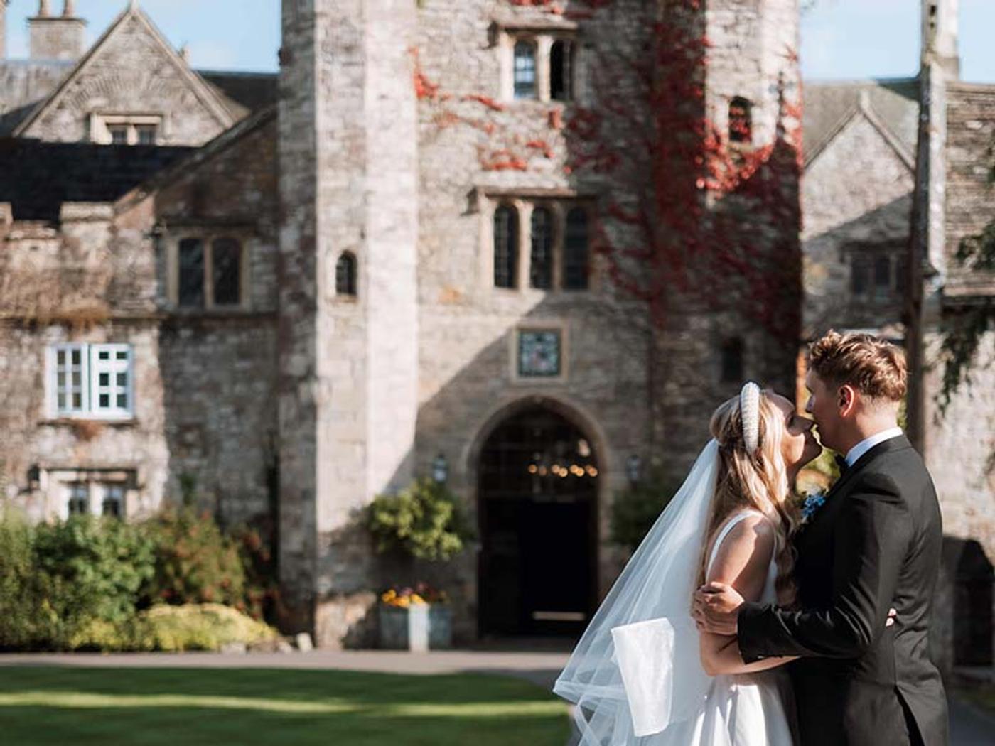 Newlyweds walking through a confetti exit with guests cheering