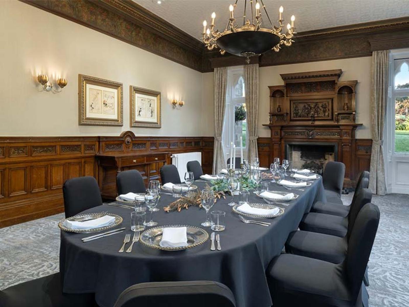 Formal dining room with carved fireplace and boardroom table