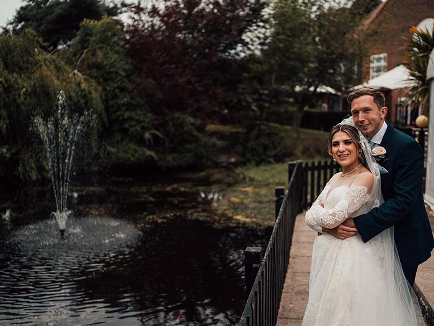 Bride and groom portrait beside the lake and fountain at Delta Hotels by Marriott Tudor Park Country Club