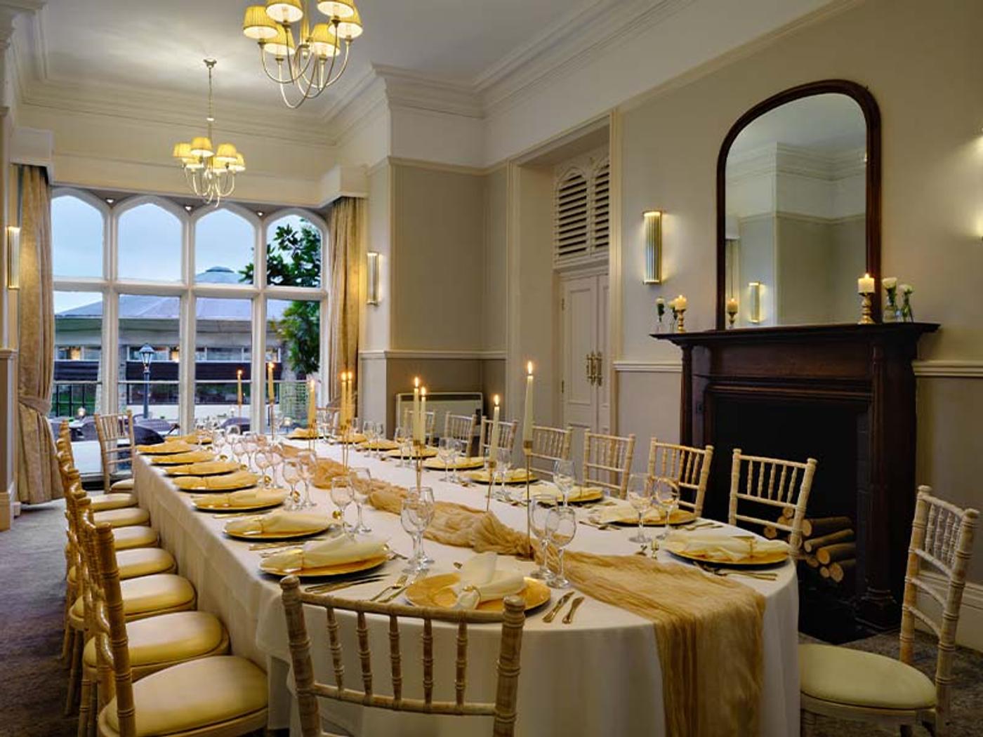 Boardroom set for a formal dinner with a chandelier and candlelit table