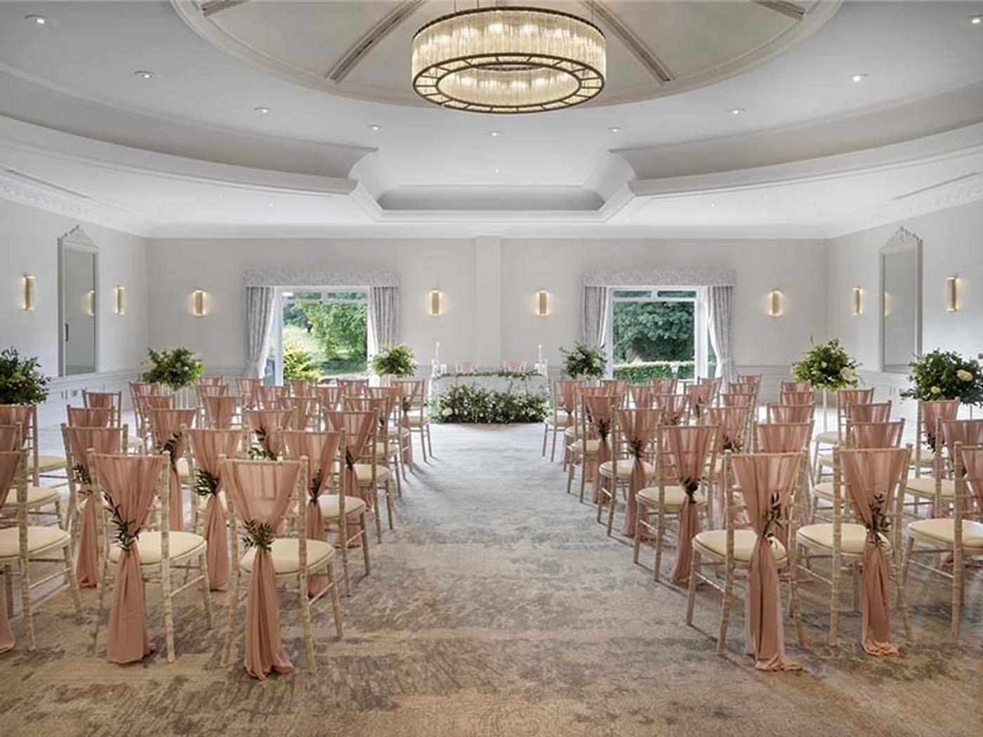 Ceremony room set up with rows of chiavari chairs beneath a chandelier at Delta Hotels St. Pierre Country Club