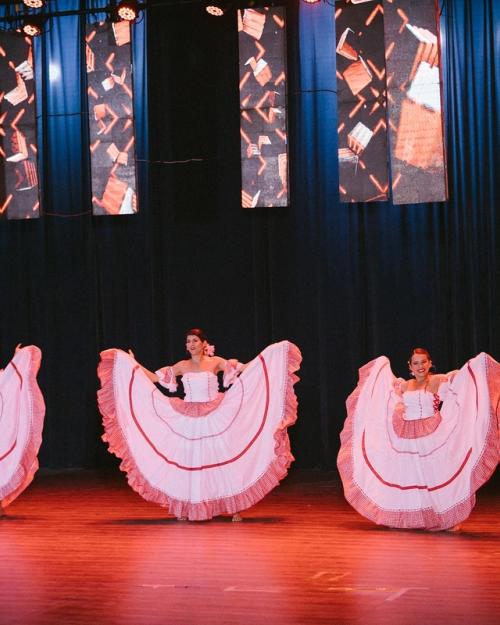 Bailarinas con pollera blanca y roja abiertas al unísono