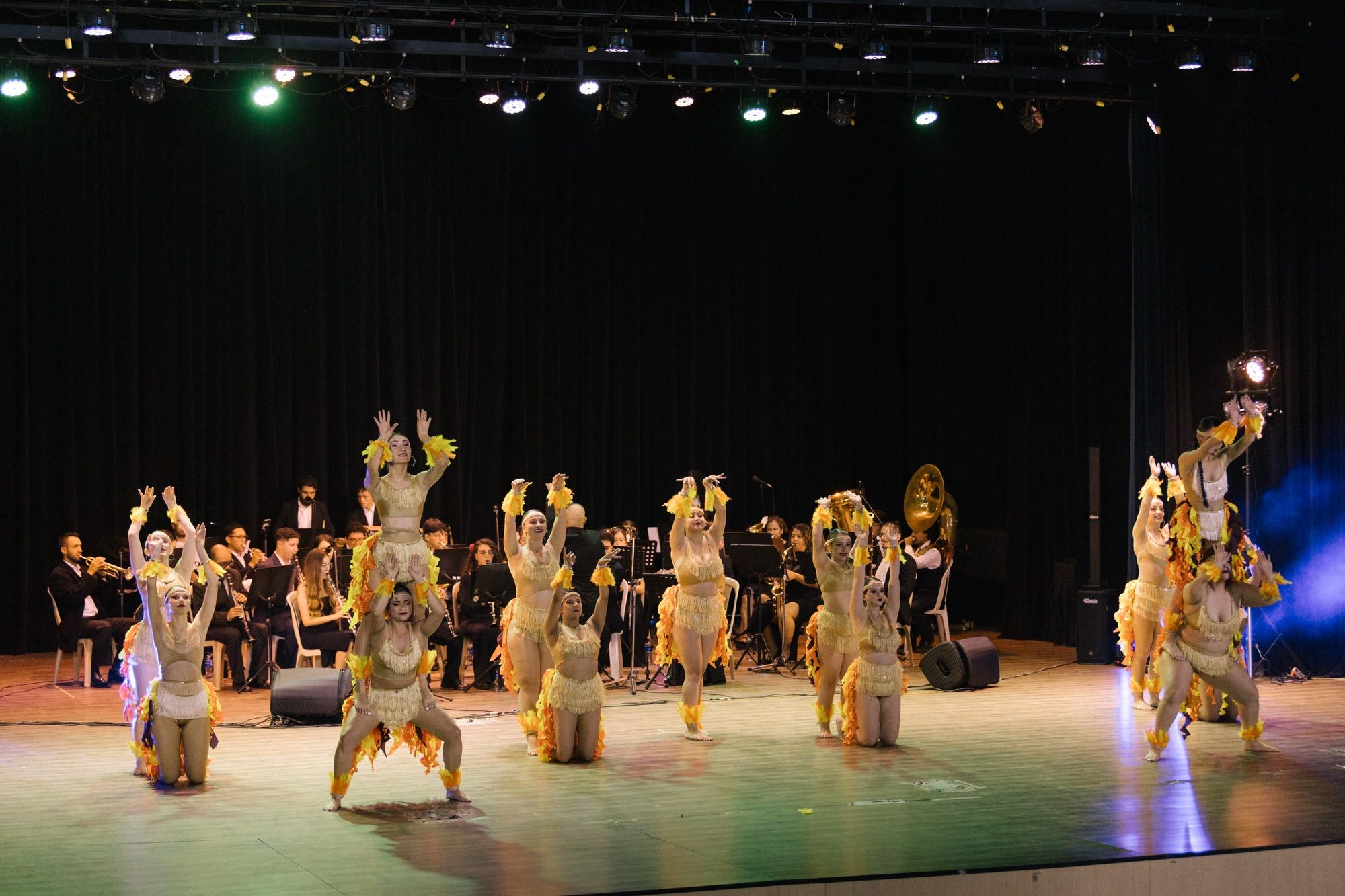 Vista del escenario con la banda al fondo y las bailarinas al frente