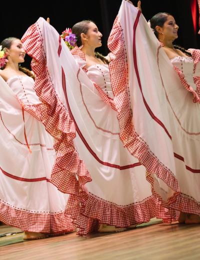Polleras blancas con ribetes rojos abiertas en pleno giro