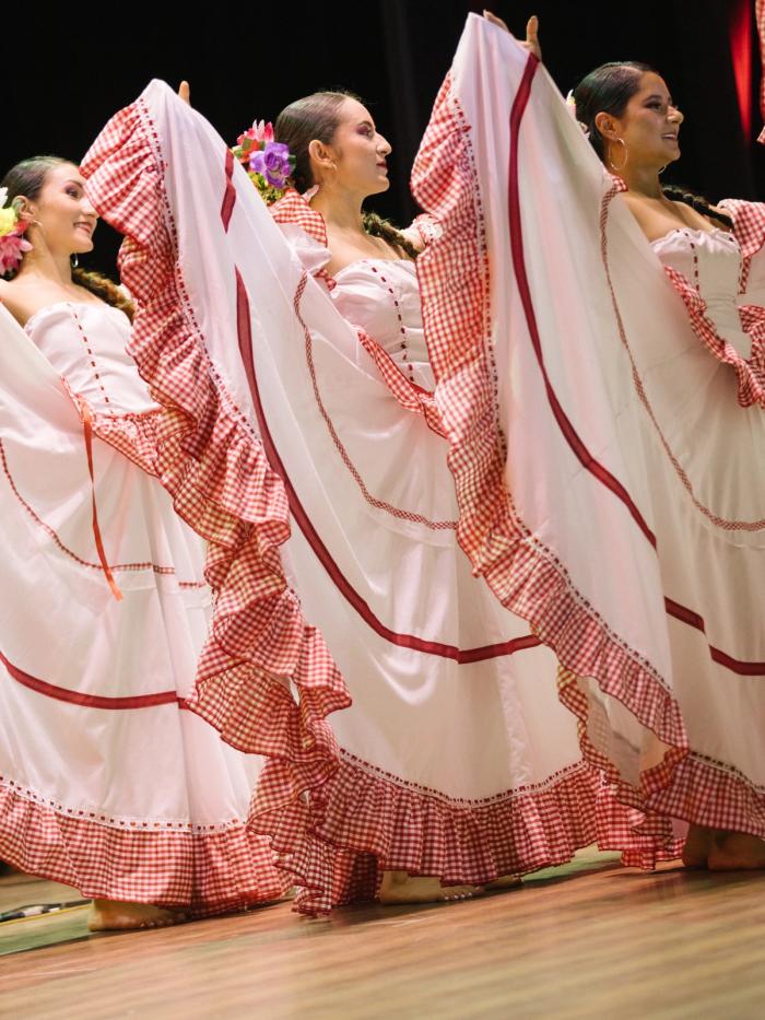 Polleras blancas con ribetes rojos abiertas en pleno giro