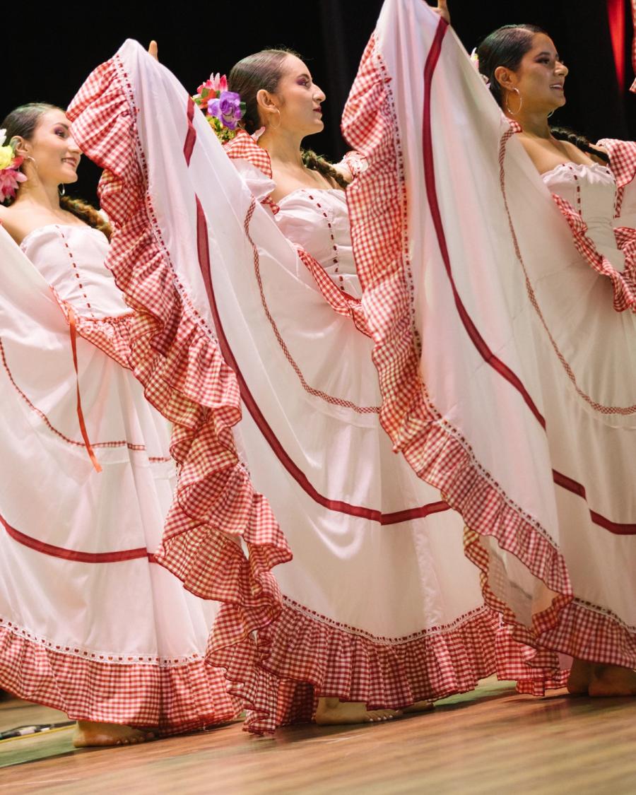 Polleras blancas con ribetes rojos abiertas en pleno giro