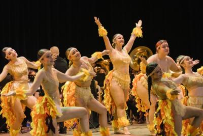 Bailarinas con vestuario de fuego frente a la banda